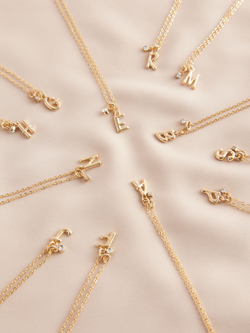 Gold tone initial necklace with letter pendant, UK version