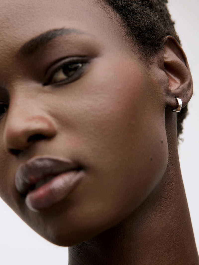 Oliver Bonas sterling silver huggie earrings with faceted surface, imported from the UK