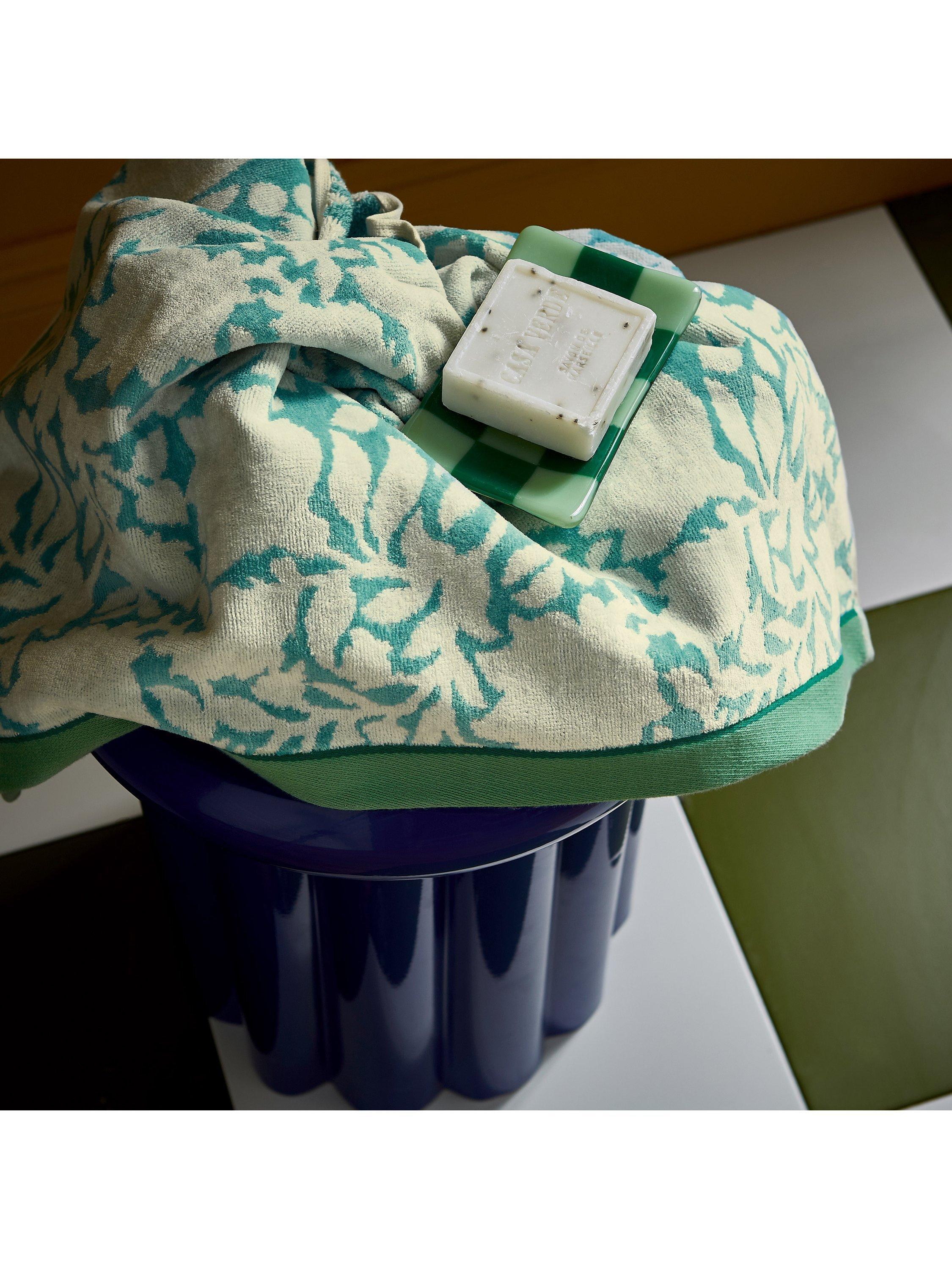 Land Shore floral blue bath towel with red and green trim, UK version