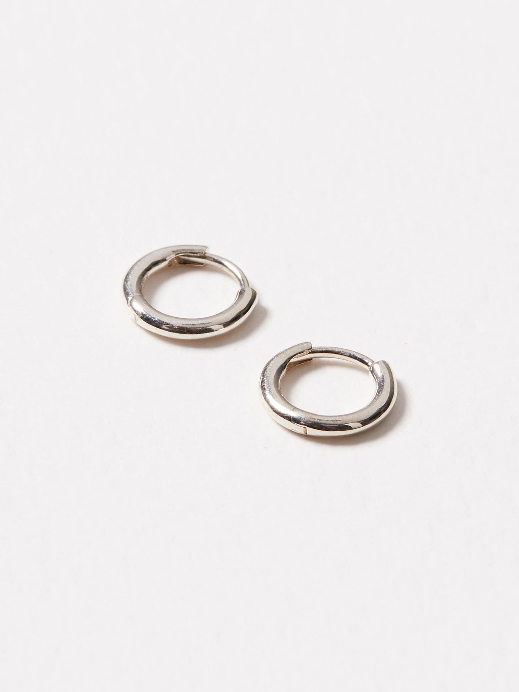 Oliver Bonas silver tone juniper mini huggie earrings, imported from the UK