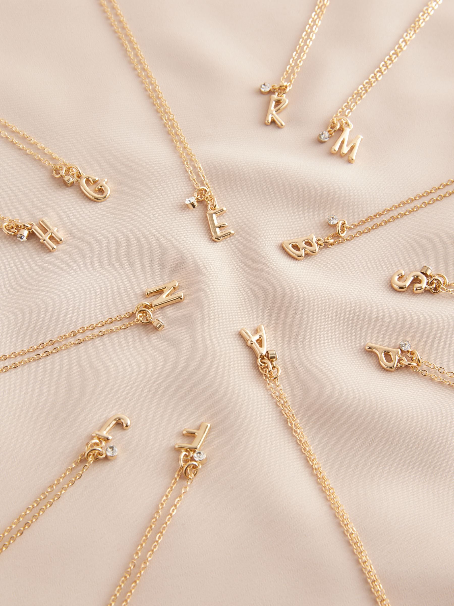 Gold tone initial necklace with letter pendant, UK version
