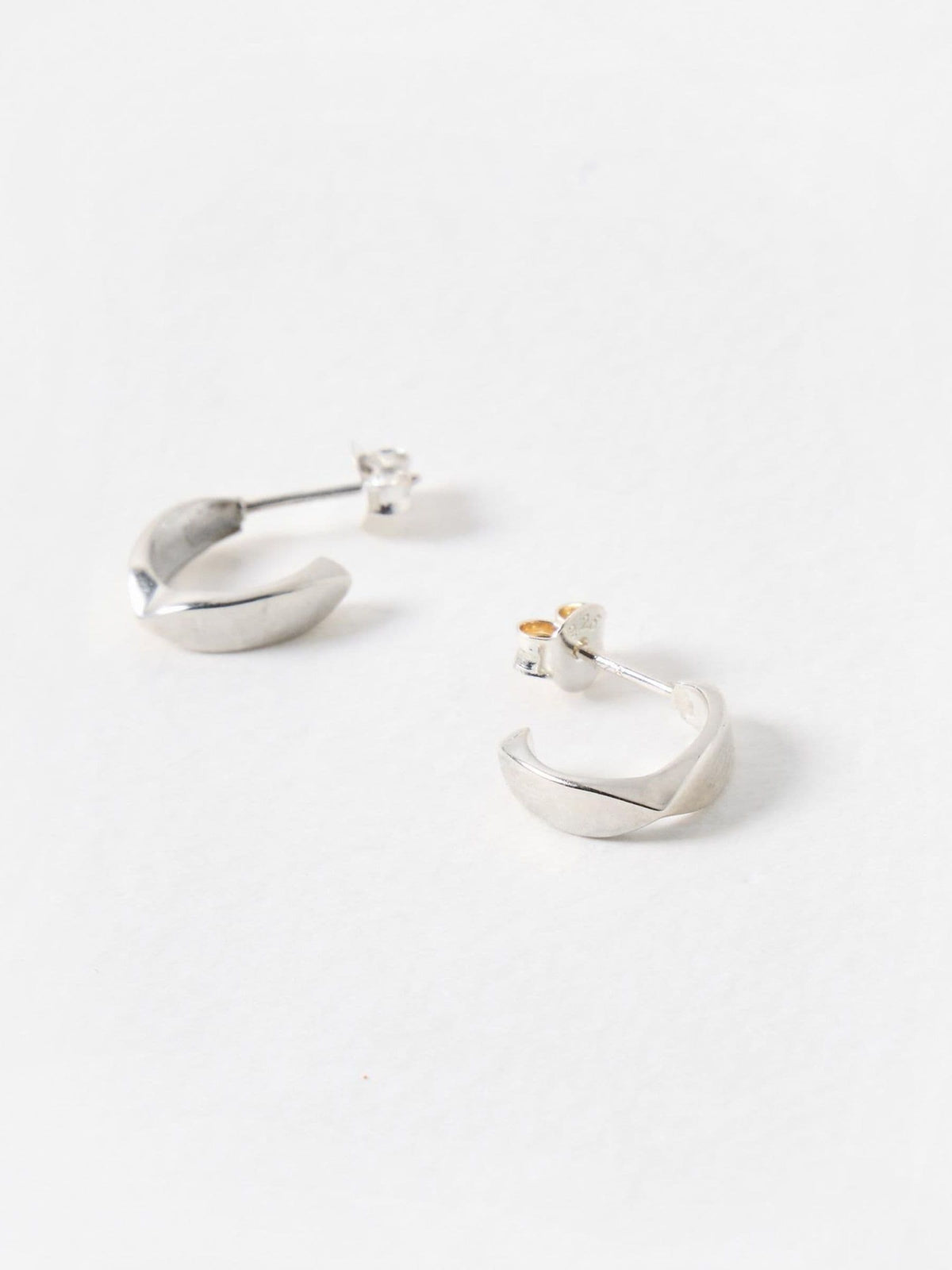 Oliver Bonas sterling silver huggie earrings with faceted surface, imported from the UK