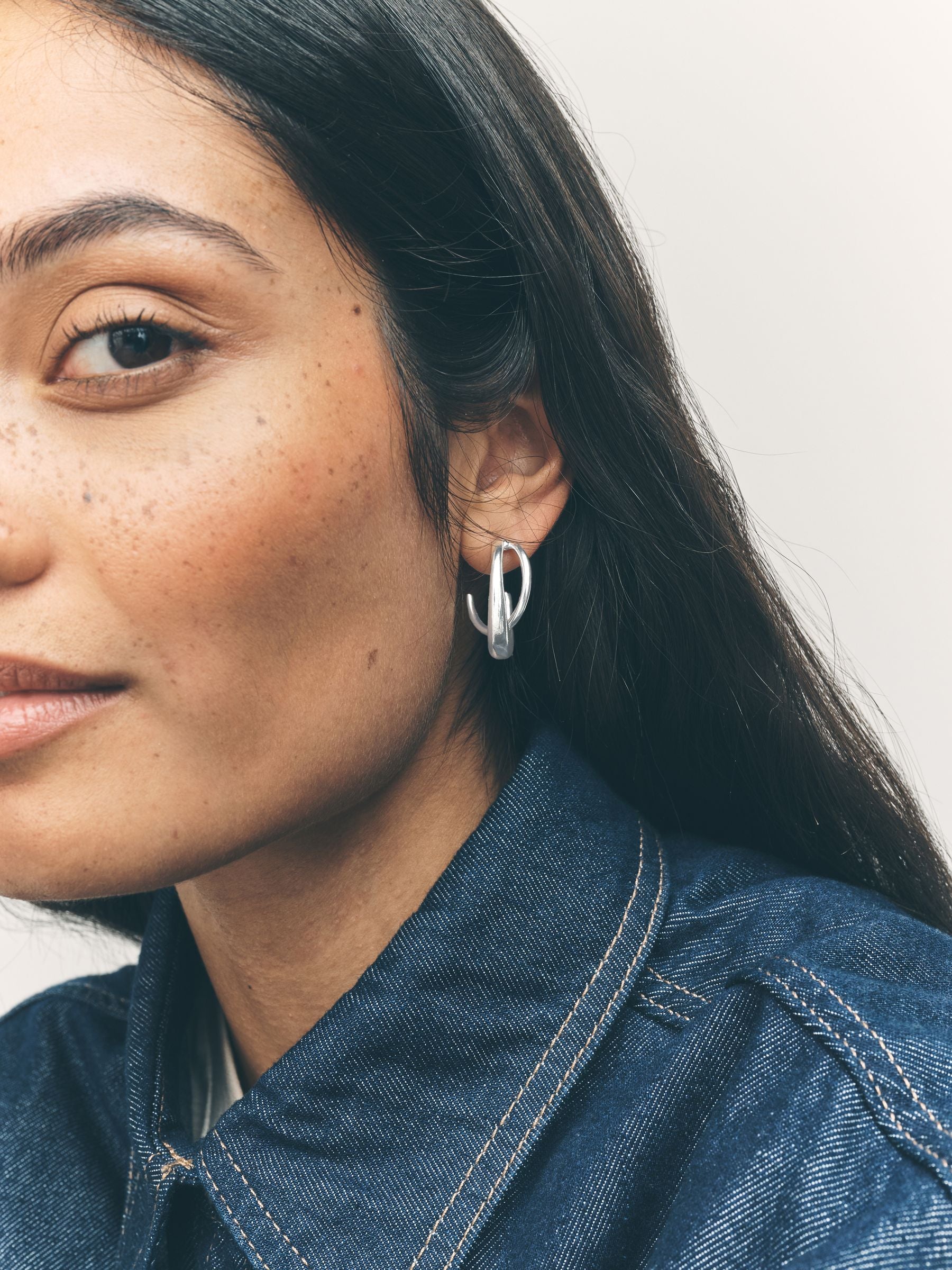 Silver tone crossover hoop earrings (British brand)