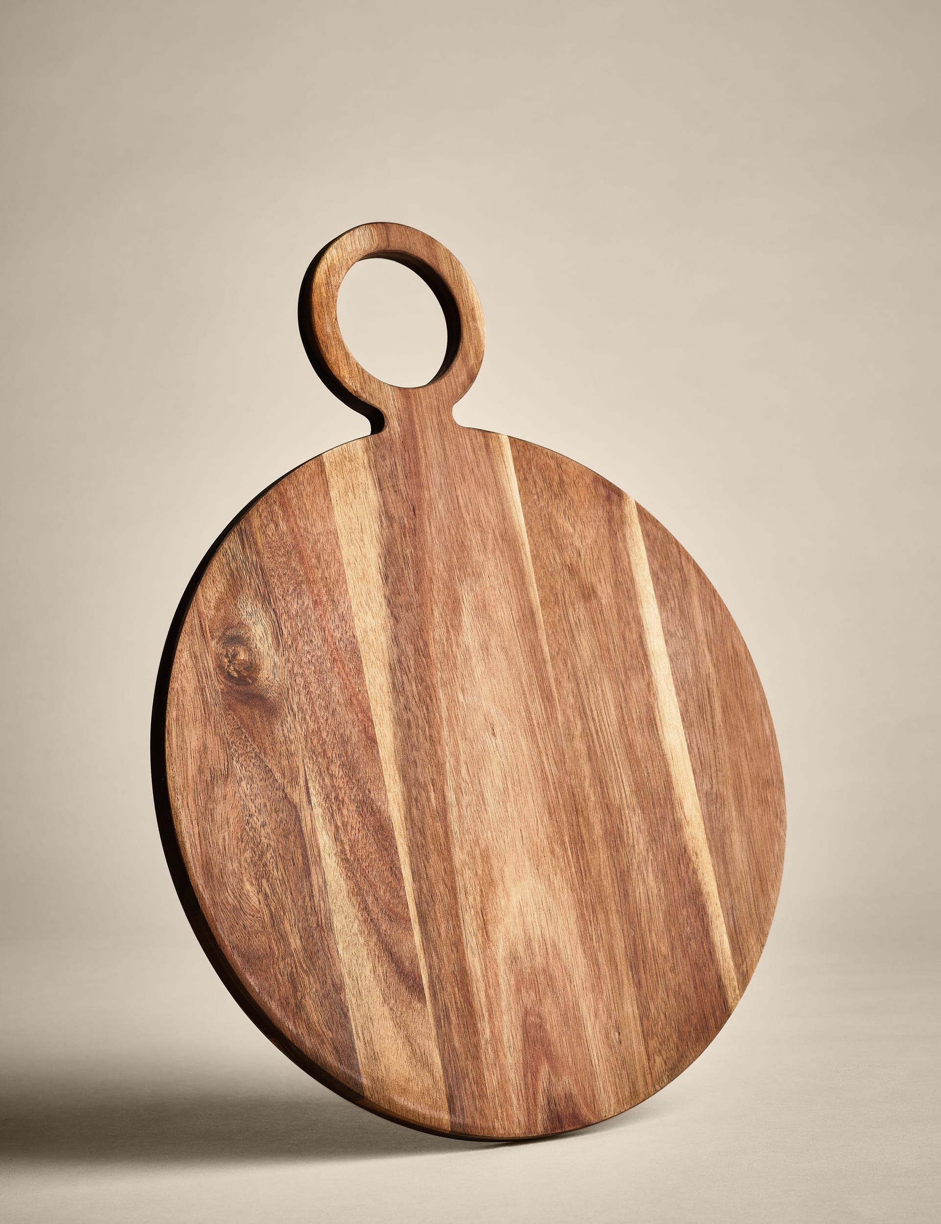 Round acacia wood serving board with handle (British brand)
